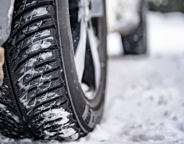 Pneumatico invernale Dettaglio di pneumatici per auto in inverno sulla strada coperta di neve