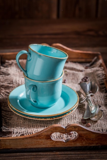 Poche tazze di caffè blu sul vecchio vassoio di legno