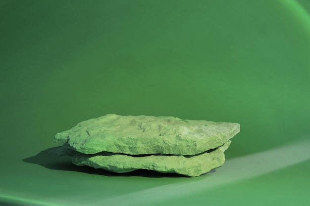 Podio in pietra per la promozione su sfondo verde Piedistallo in roccia naturale Vetrina, display mockup. Scena
