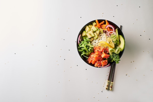 Poke bowl con bacchette di salmone, avocado, cetriolo, rucola