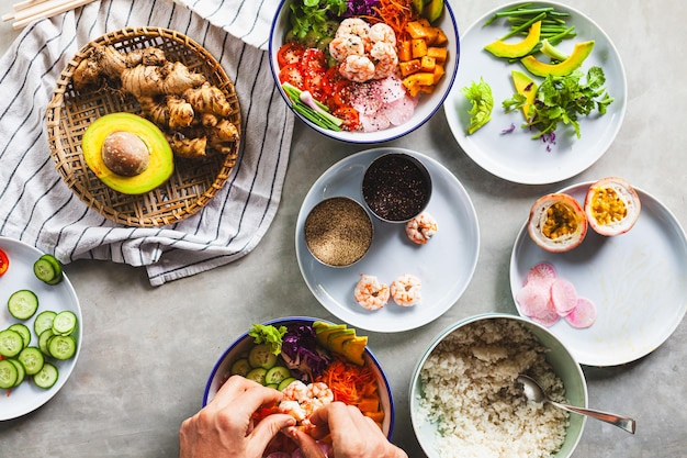 Poke bowl con gamberetti preparati dallo chef contenenti riso bianco mango avocado pomodoro ecc.