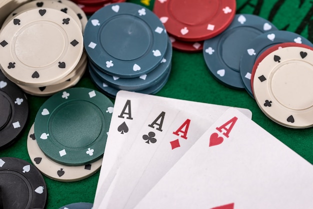 Poker chips e quattro asso sul tavolo verde