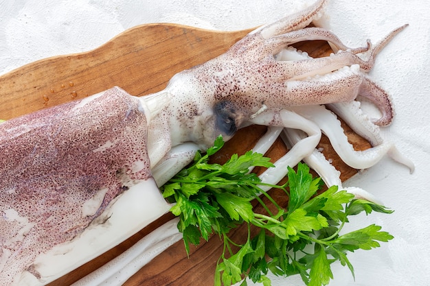 Polipo crudo fresco con prezzemolo sul tagliere