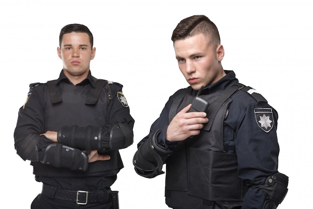 Poliziotti in uniforme e giubbotto antiproiettile su bianco isolato