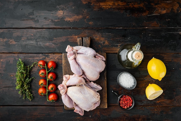 Polli crudi coquelet carne con ingredienti, su un vecchio tavolo di legno, vista dall'alto
