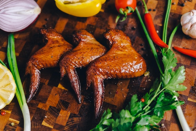 pollo affumicato pollo cotto in un affumicatoio su una tavola da taglio decorato con verdure pepe peperoncino peperone limone rosmarino cipolla