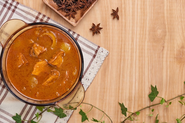 Pollo al curry con spezie su fondo in legno