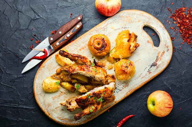 Pollo al forno con mele, affettato su un tagliere da cucina