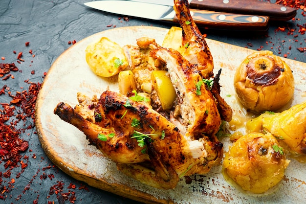 Pollo al forno con mele, affettato su un tagliere da cucina