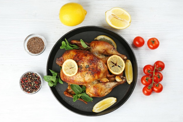 Pollo al forno fatto in casa con limone e menta sul tavolo