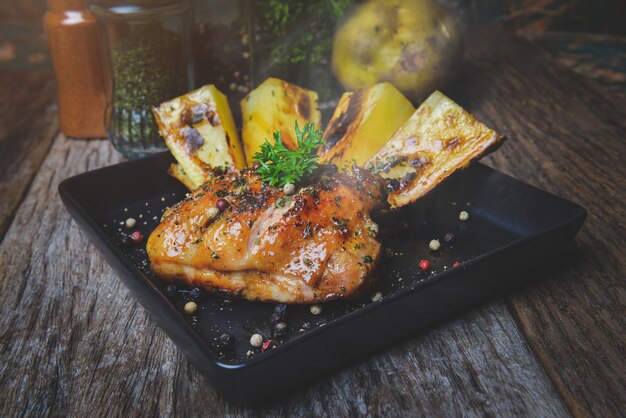 Pollo alla griglia arrosto su un piatto nero