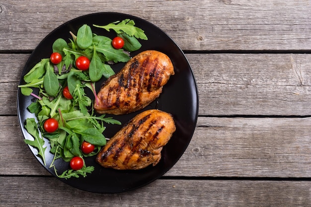 Pollo alla griglia con spinaci e insalata di pomodori Sfondo di cibo per barbecue