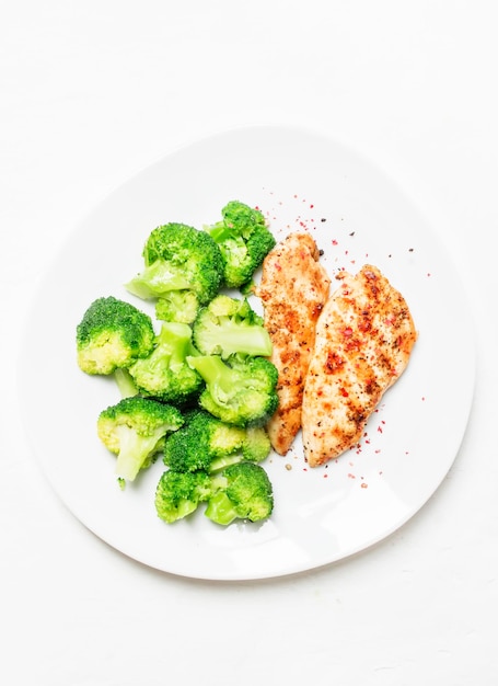 Pollo alla griglia e broccoli pranzo sano sfondo bianco vista dall'alto