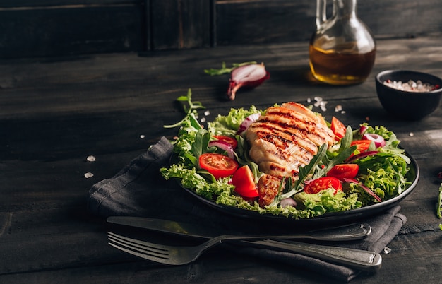 Pollo alla griglia e insalata sul tavolo