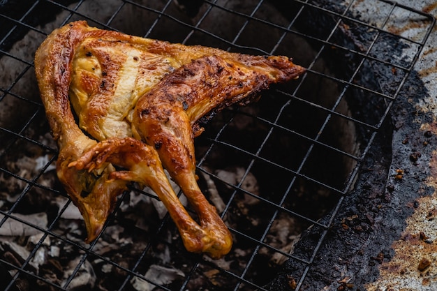 Pollo alla griglia su una stufa a carbone