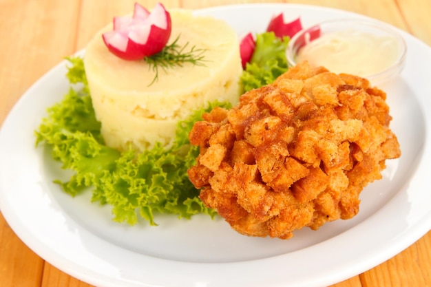 Pollo alla Kiev su crostini di pane con purè di patate su fondo di legno