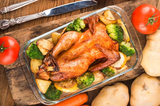 pollo arrosto e verdure sulla tavola di legno