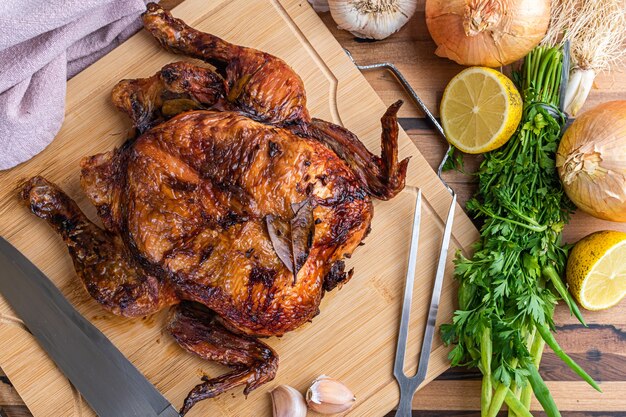 Pollo arrosto servito sulla tavola di legno sul tavolo.