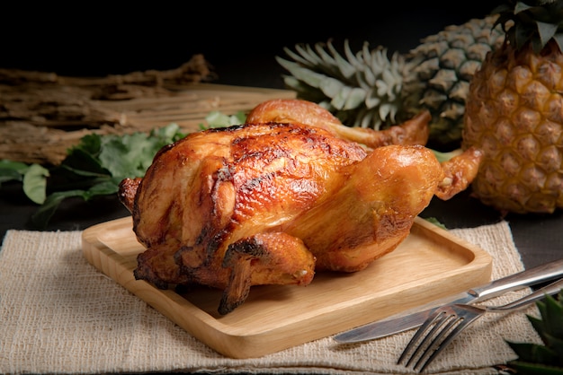 Pollo arrosto su un piatto di legno.