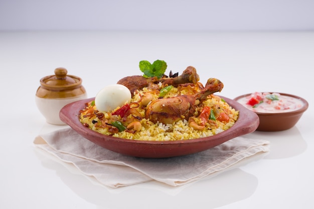 Pollo biryani Kerala dum biriyani realizzato con riso jeera e spezie disposti in terracotta