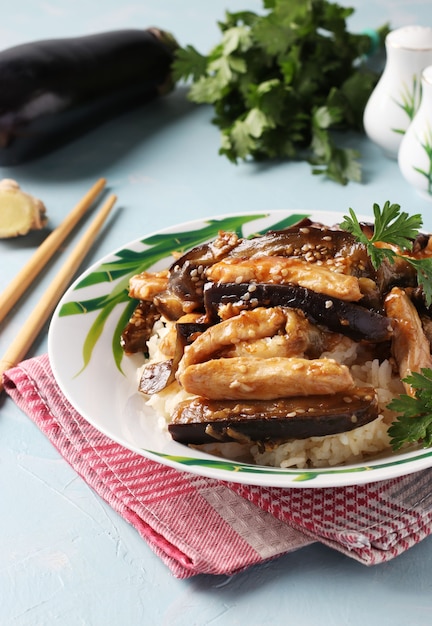 Pollo con melanzane in salsa piccante. Spuntino casalingo asiatico delizioso sulla tavola blu-chiaro.