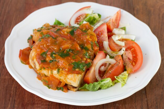 Pollo con salsa e insalata sul piatto