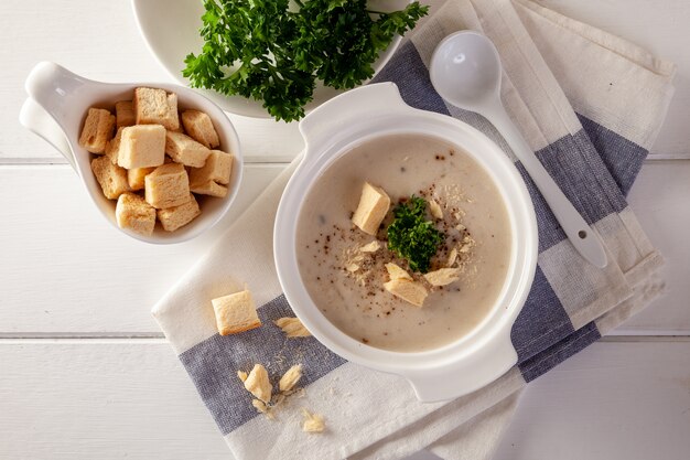 Pollo cremoso e verdure su una tavola di legno bianca