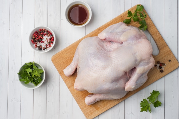Pollo crudo fresco sul tagliere e spezie per cucinare