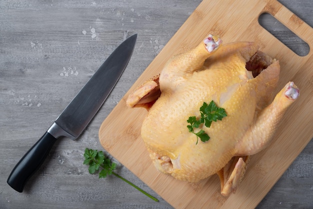 Pollo crudo su un tagliere e un coltello