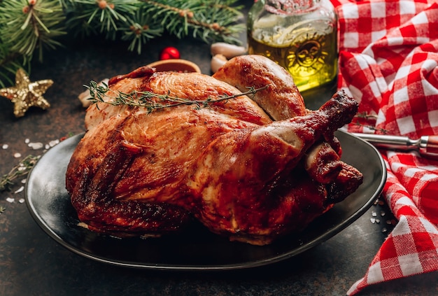 Pollo fatto in casa arrosto con timo, aglio su un piatto nero