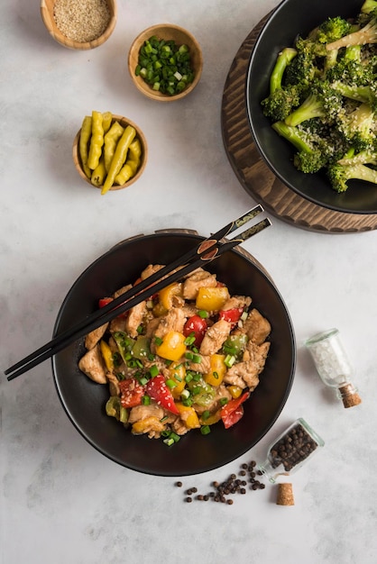 Pollo fritto con peperone giallo e verde rosso sul tagliere di legno