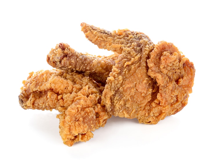 Pollo fritto isolato sulla parete bianca.