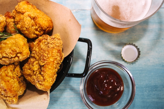 Pollo fritto vicino a birra e ketchup