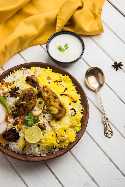 Pollo Hyderabadi o dum biryani, servito in un Kadhai o in una ciotola con salsa allo yogurt. messa a fuoco selettiva