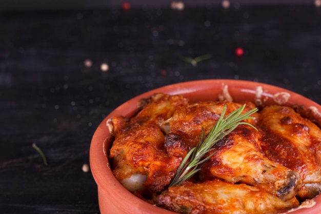 Pollo in salsa di paprika al forno in ceramica. Cosce di pollo e ali