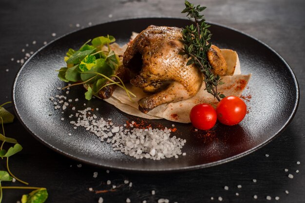 Pollo intero alla griglia con verdure su sfondo nero