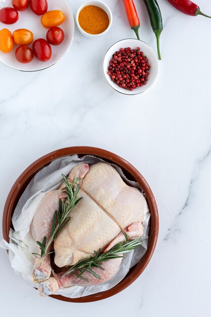 Pollo intero crudo con erbe e spezie