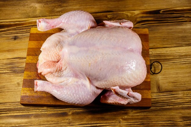 Pollo intero crudo su un tavolo di legno Vista dall'alto