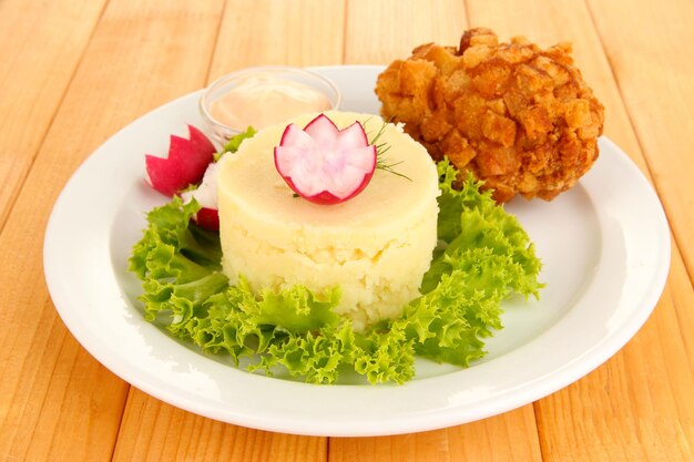 Pollo Kiev su crouton con purè di patate su sfondo di legno