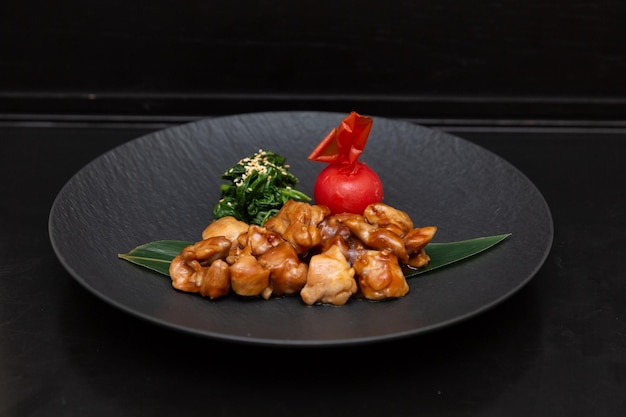 Pollo Kung Pao o Gong Bao Ji Ding su sfondo ardesia scuro Sichuan Kung Pao è un piatto di cucina cinese con carne di pollo peperoncino salse di arachidi e cipolla