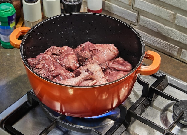 Pollo marinato al vino rosso con rosmarino in casseruola sul fornello a gas