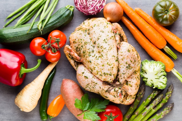 Pollo piccante alla griglia, verdure su grigio. Vista dall'alto.