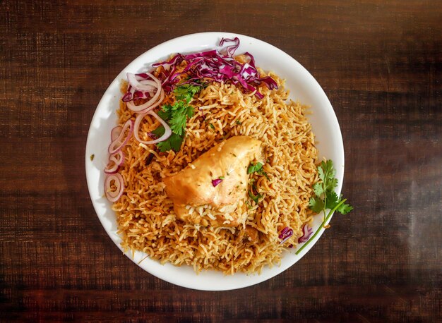 Pollo pulao con cipolla e cavolo servito in piatto isolato sfondo in legno vista dall'alto spezie indiane e cibo pakistano