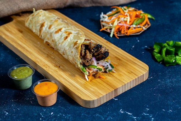 Pollo Reshmi Tikka shawarma Avvolgere con salsa di insalata e salsa isolata tavola di legno vista laterale del fastfood