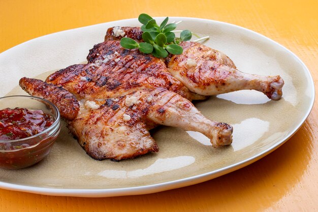 Pollo tapaka in una performance classica con crosta d'aglio croccante e salsa georgiana