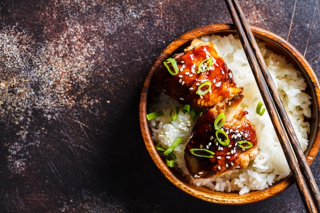 Pollo Teriyaki con riso bianco in una ciotola di legno.