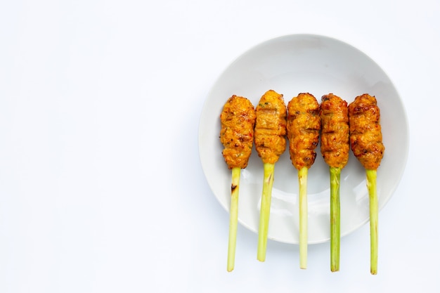 Pollo tritato alla griglia con pasta di curry e crema di cocco su spiedini di citronella