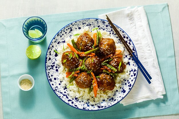 Polpette asiatiche vegane senza carne in salsa agrodolce con riso e verdure in umido. pranzo equilibrato o cena sana. cibo di strada