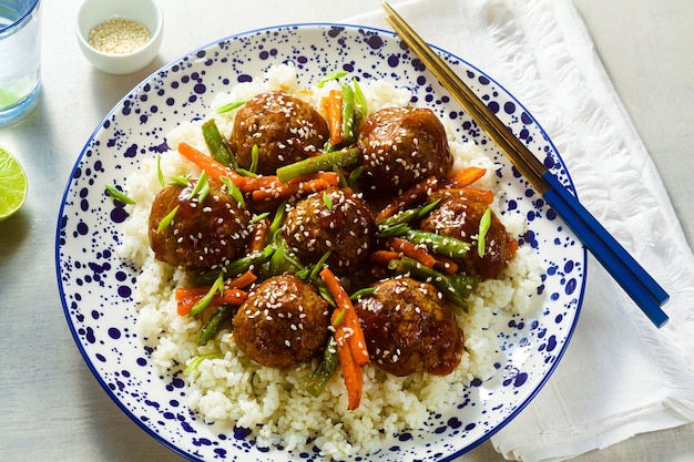 Polpette asiatiche vegane senza carne in salsa agrodolce con riso e verdure in umido. pranzo equilibrato o cena sana. cibo di strada