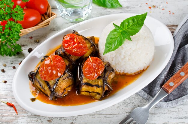 Polpette avvolte in melanzane su un piatto di riso